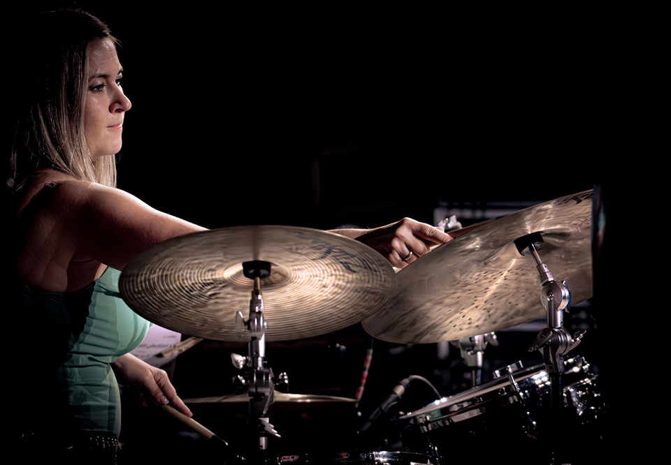 Kvinna som spelar trummor. Fotografi.
