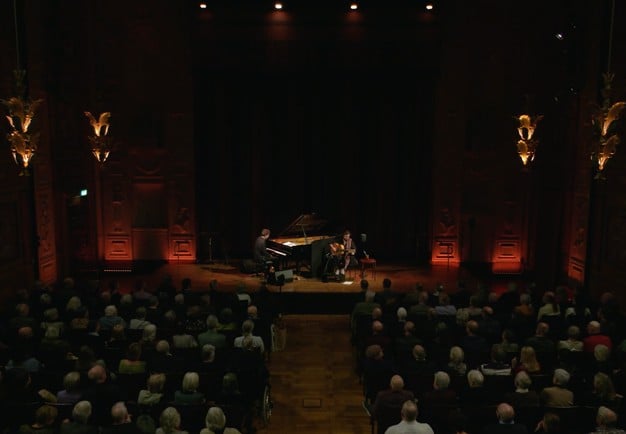 utdrag ur filmen. Pianist och gitarrist spelar.
