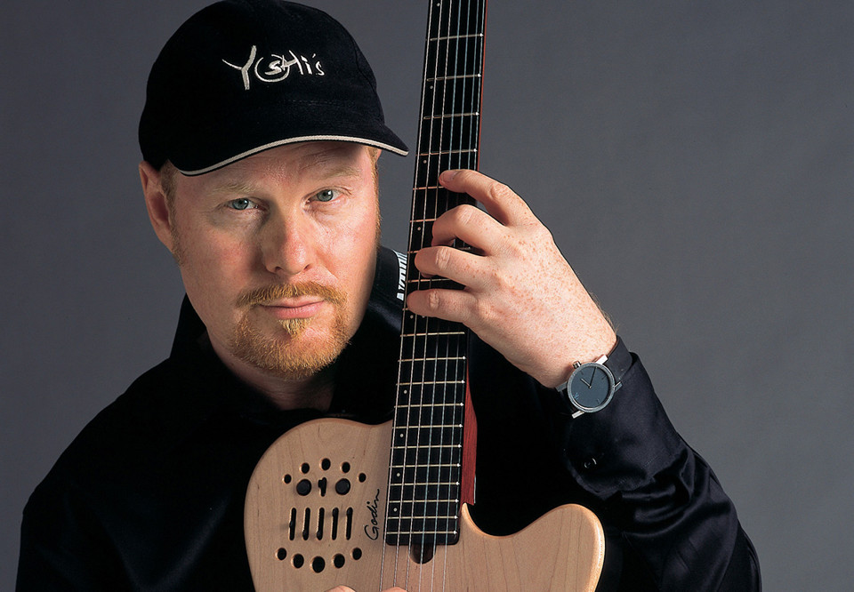 Man som håller i en gitarr. Fotografi.