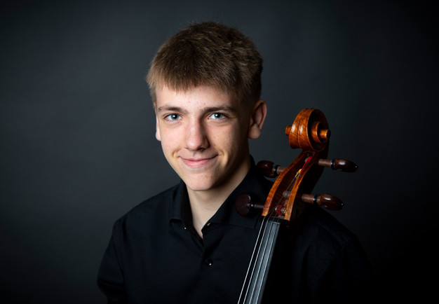 Ung kilel med cello. Fotografi.