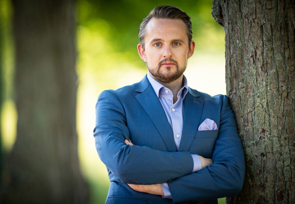 Man som lutar sig mit ett träd. Fotografi.